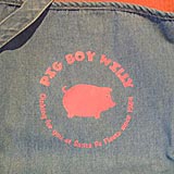 Closeup of the Pig Boy Willy Logo silkscreened onto a denim apron